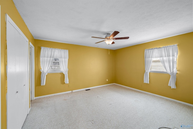 carpeted empty room with a textured ceiling and ceiling fan