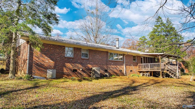 rear view of property with a lawn and a wooden deck