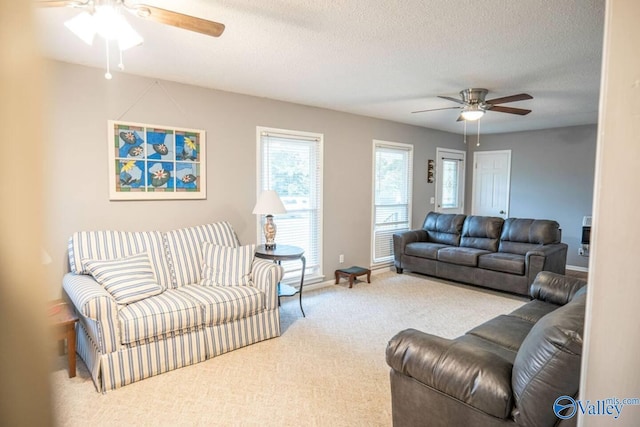 living room featuring a textured ceiling, carpet flooring, and ceiling fan