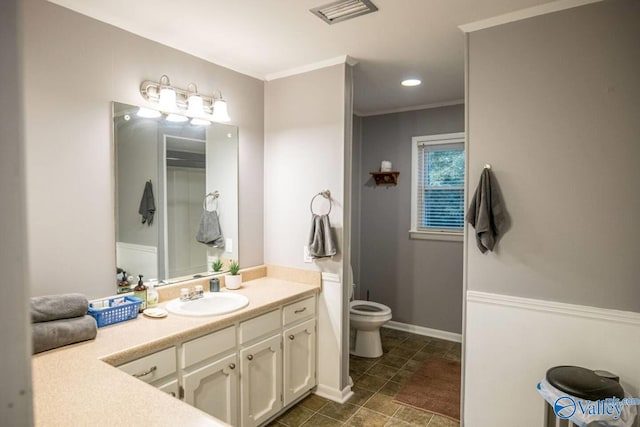 bathroom featuring toilet, vanity, and crown molding