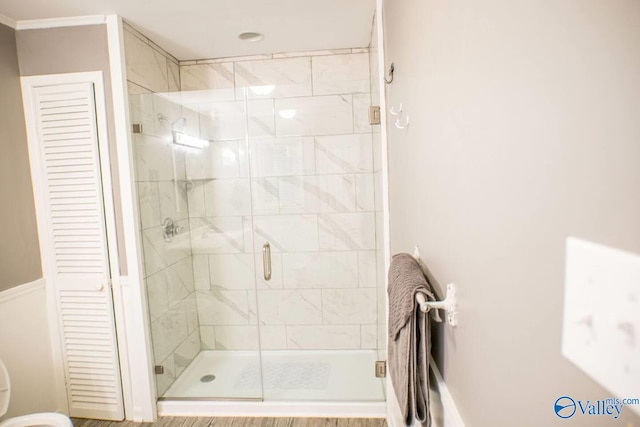 bathroom with wood-type flooring and a shower with door