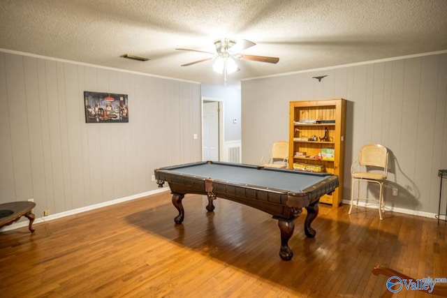 rec room featuring wood-type flooring, crown molding, a textured ceiling, wooden walls, and pool table