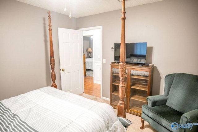 bedroom featuring a textured ceiling and light colored carpet