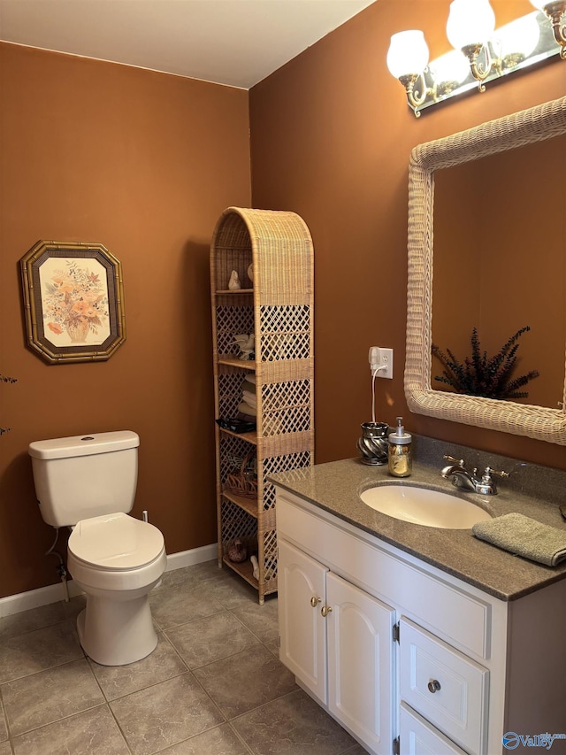bathroom featuring baseboards, toilet, tile patterned flooring, and vanity