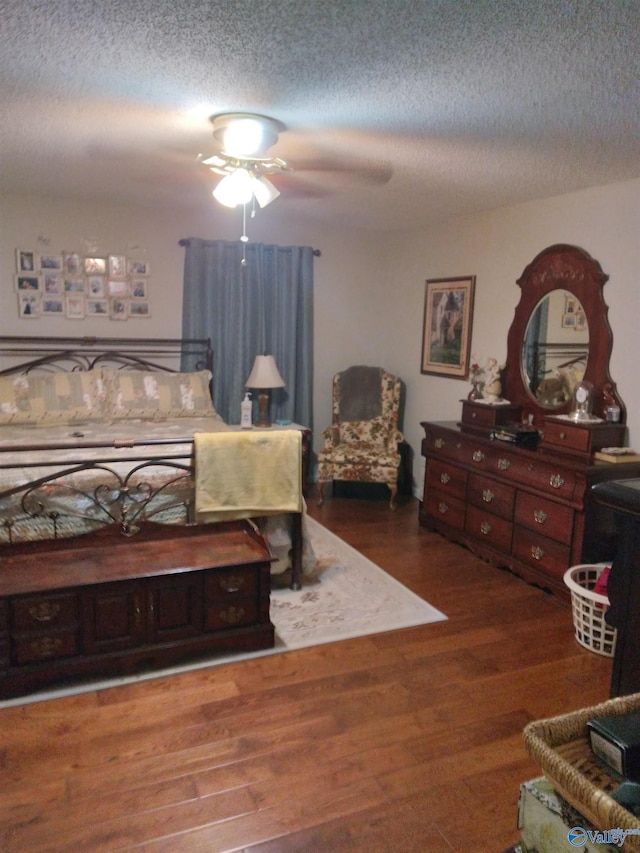 bedroom with wood finished floors, ceiling fan, and a textured ceiling