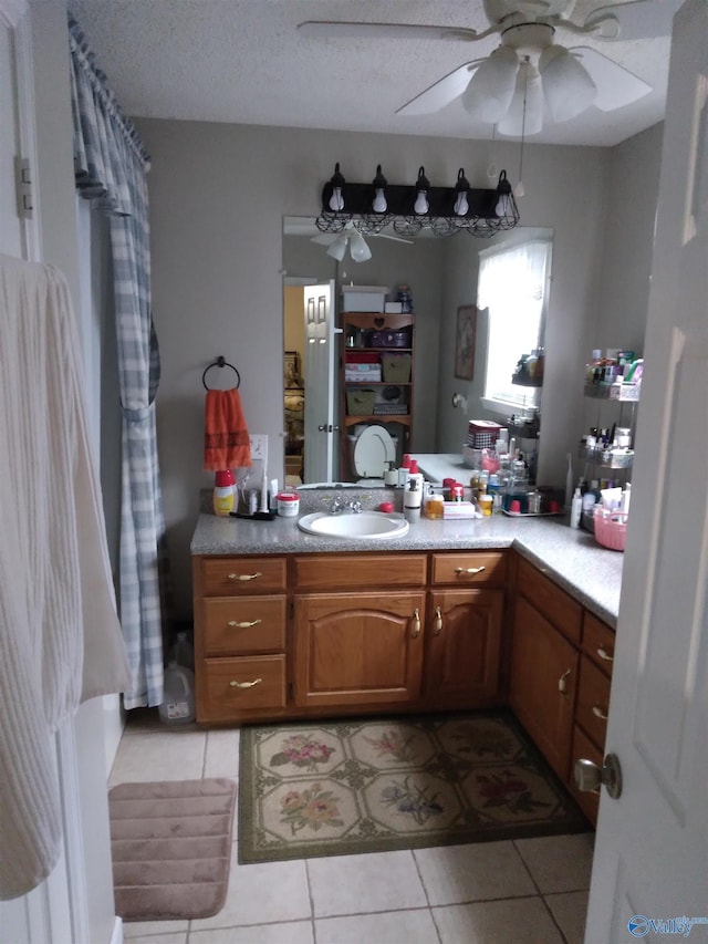 bathroom featuring a textured ceiling, ceiling fan, tile patterned floors, and vanity