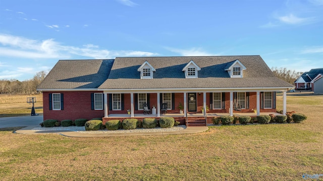 cape cod home featuring a porch and a front lawn