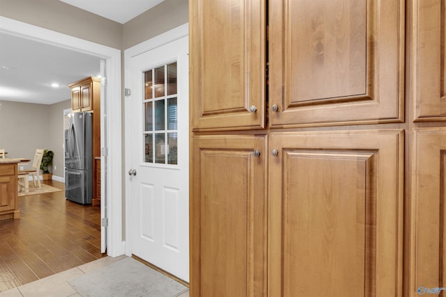 interior space featuring stainless steel refrigerator and wood-type flooring