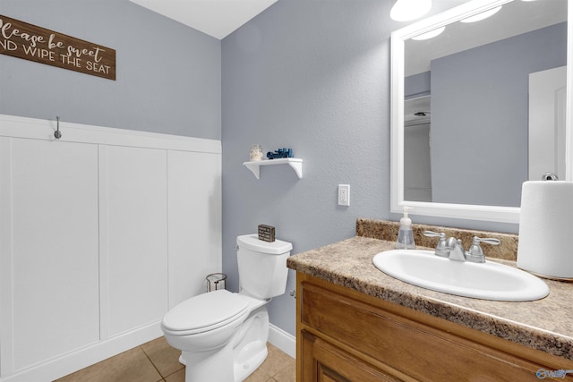 bathroom with toilet, tile patterned flooring, and vanity