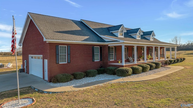 view of home's exterior with a garage, covered porch, and a lawn