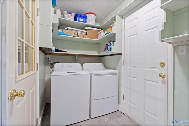 washroom with washer and dryer and a textured ceiling