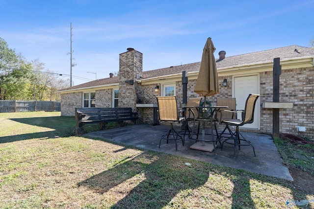 rear view of house with a lawn and a patio