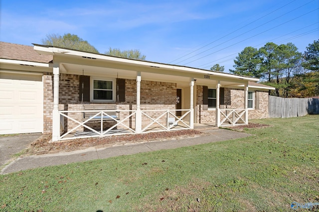 ranch-style home featuring a front yard, a garage, and covered porch