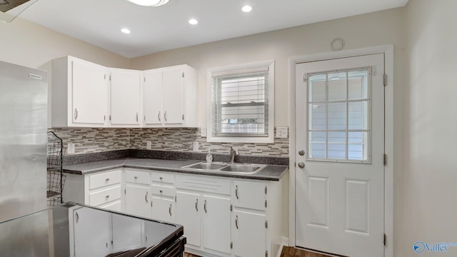 4212 Mcclain Ln NW, Huntsville, AL 35810 - kitchen with a sink, freestanding refrigerator, dark countertops, tasteful backsplash, and white cabinets