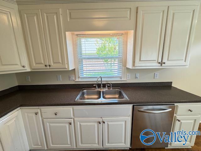 15031 Ashmont Blvd SE, Huntsville, AL 35803 - kitchen with dishwasher, white cabinets, dark countertops, and a sink