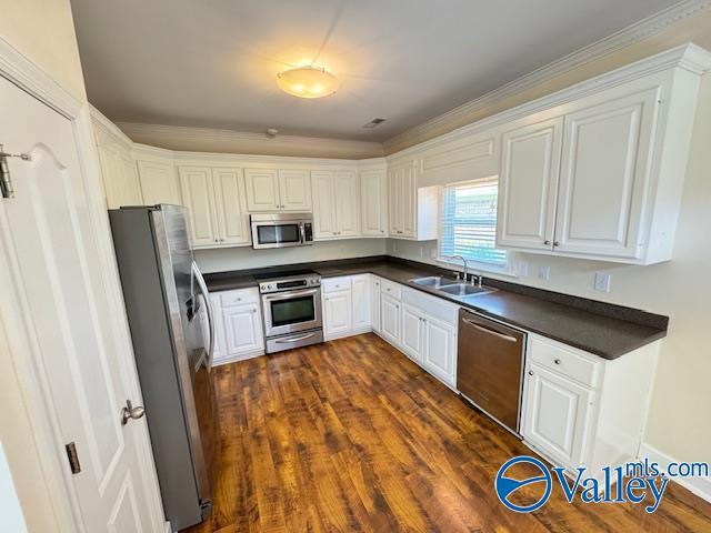 15031 Ashmont Blvd SE, Huntsville, AL 35803 - kitchen with dark countertops, stainless steel appliances, white cabinetry, and a sink