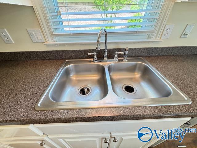 15031 Ashmont Blvd SE, Huntsville, AL 35803 - room details with dark countertops, a sink, and white cabinetry