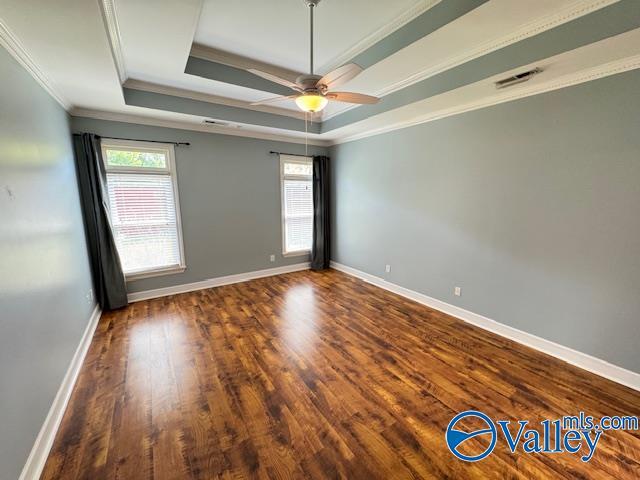 15031 Ashmont Blvd SE, Huntsville, AL 35803 - empty room featuring a raised ceiling, wood finished floors, visible vents, crown molding, and ceiling fan