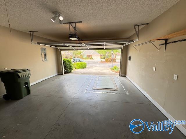 15031 Ashmont Blvd SE, Huntsville, AL 35803 - garage featuring baseboards and a garage door opener