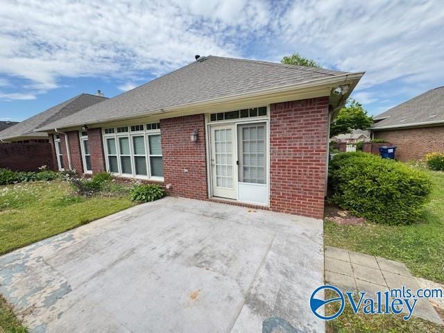 15031 Ashmont Blvd SE, Huntsville, AL 35803 - back of property featuring brick siding, a yard, a patio, and a shingled roof