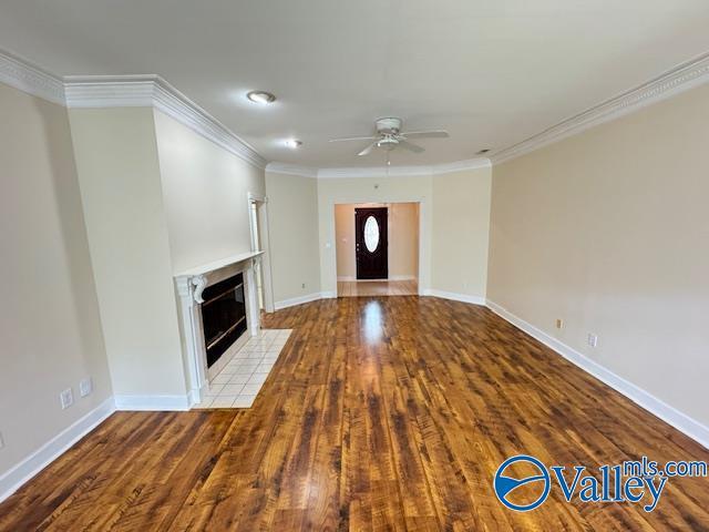 15031 Ashmont Blvd SE, Huntsville, AL 35803 - unfurnished living room with baseboards, wood finished floors, ceiling fan, a fireplace, and ornamental molding