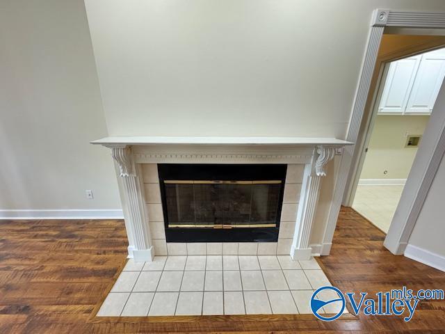 15031 Ashmont Blvd SE, Huntsville, AL 35803 - details featuring baseboards, wood finished floors, and a fireplace