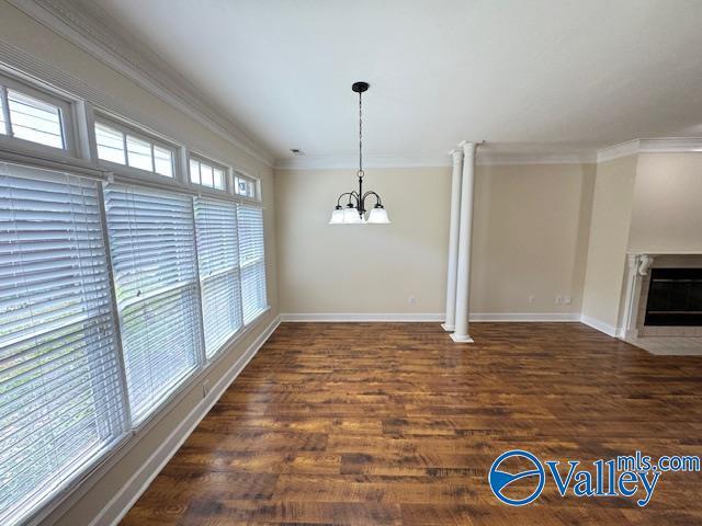 15031 Ashmont Blvd SE, Huntsville, AL 35803 - unfurnished dining area featuring wood finished floors, baseboards, an inviting chandelier, and ornamental molding