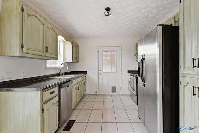 1502 Bower Dr SE, Cullman, AL 35055 - kitchen featuring light tile patterned floors, a textured ceiling, a sink, dark countertops, and appliances with stainless steel finishes