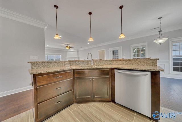 kitchen with ornamental molding, hanging light fixtures, stainless steel dishwasher, and a sink