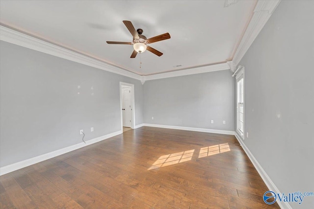 spare room featuring crown molding, ceiling fan, dark wood-type flooring, and baseboards