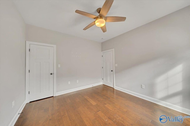 unfurnished room featuring a ceiling fan, baseboards, and wood finished floors