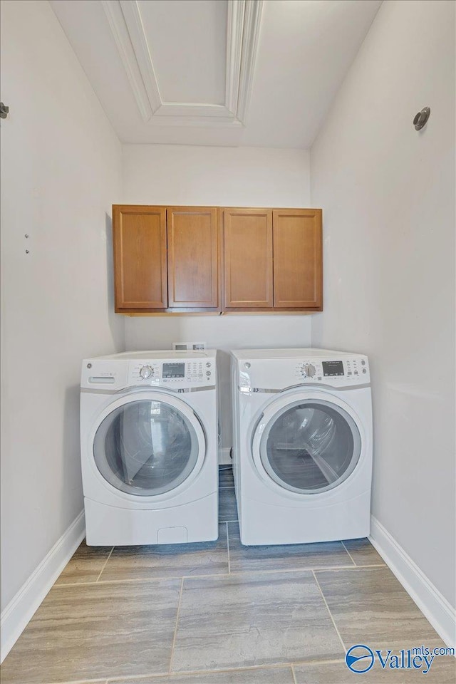 washroom with cabinet space, washing machine and dryer, wood tiled floor, and baseboards