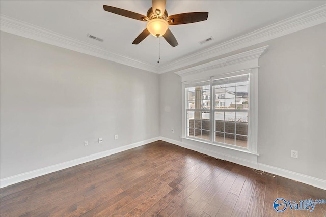 empty room featuring crown molding, visible vents, dark wood-type flooring, ceiling fan, and baseboards