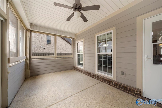 unfurnished sunroom featuring a ceiling fan