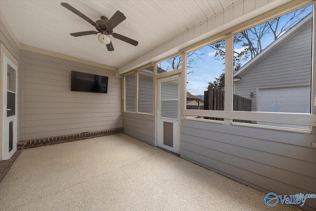 unfurnished sunroom featuring ceiling fan