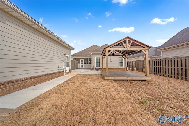 view of yard featuring a patio area, a fenced backyard, a deck, and a gazebo