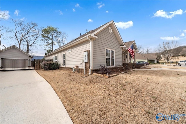 view of side of property featuring fence and a lawn