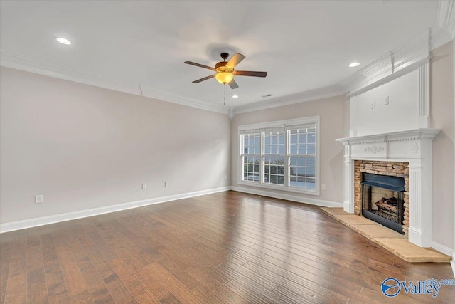 unfurnished living room featuring baseboards, a ceiling fan, ornamental molding, wood finished floors, and a fireplace