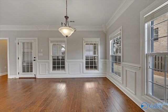 unfurnished dining area featuring visible vents, ornamental molding, dark wood-style flooring, and wainscoting