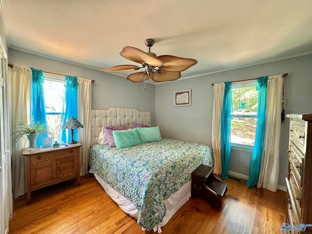 bedroom featuring hardwood / wood-style flooring, ornamental molding, and ceiling fan