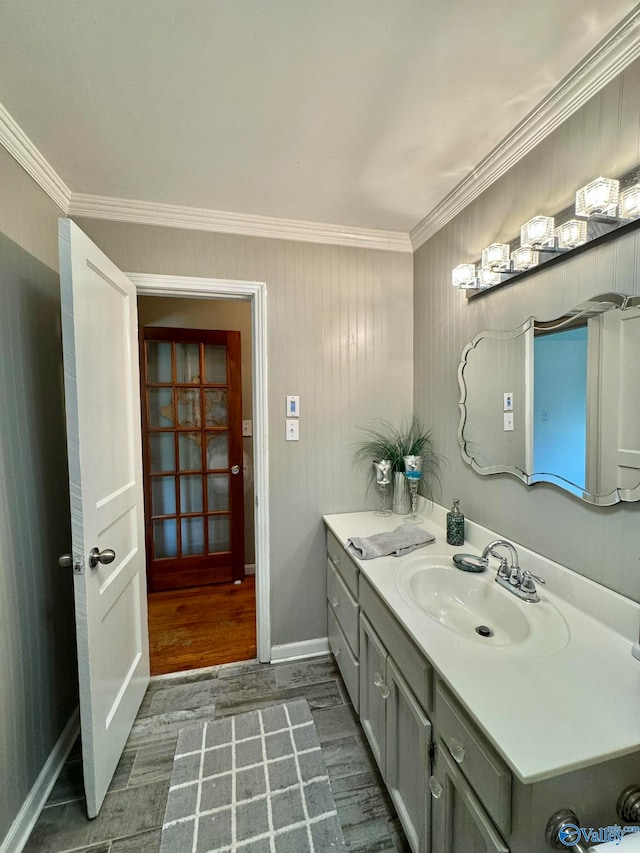 bathroom featuring hardwood / wood-style flooring, ornamental molding, and vanity