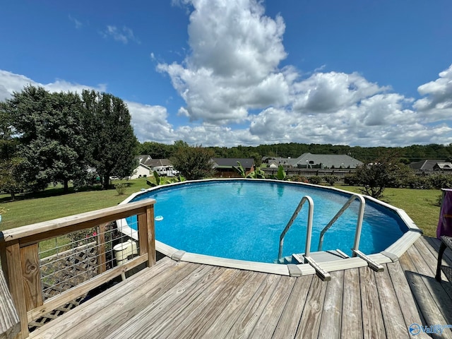 view of swimming pool featuring a wooden deck and a yard