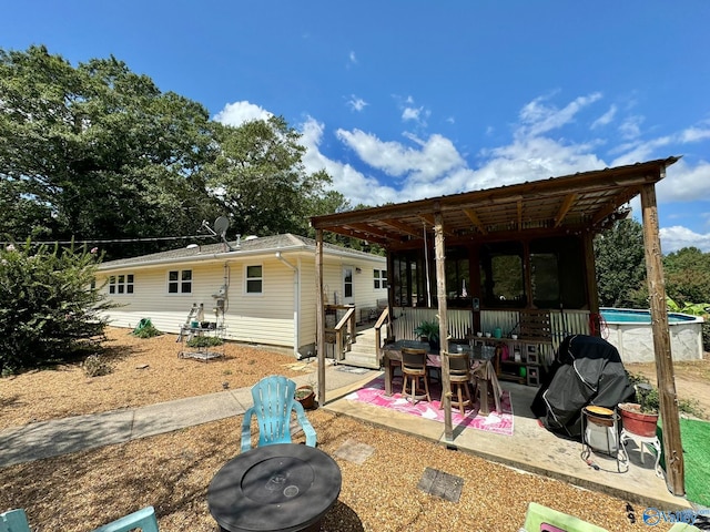 back of property featuring a patio area and a pergola