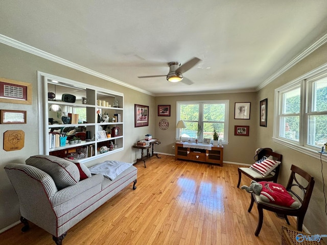 living room with ceiling fan, ornamental molding, and light wood-type flooring