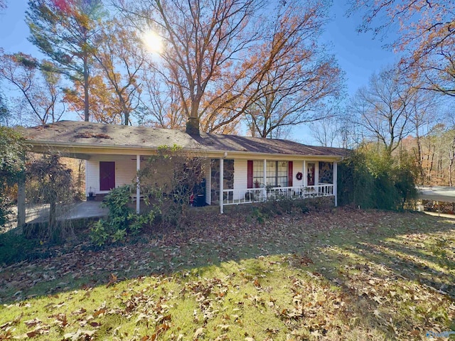 ranch-style house with a patio area, covered porch, and a front yard