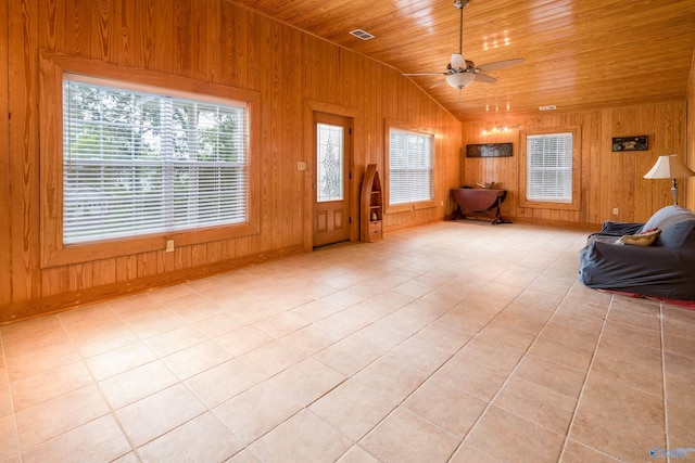 unfurnished room with light tile patterned flooring, lofted ceiling, wooden walls, ceiling fan, and wooden ceiling