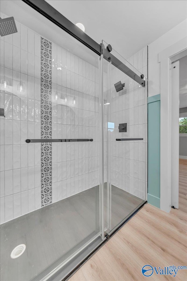 bathroom featuring tiled shower and wood finished floors