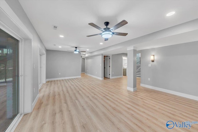 unfurnished living room with recessed lighting, visible vents, light wood-style floors, baseboards, and stairs