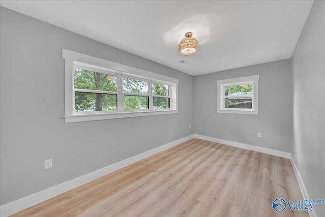 empty room with light wood-type flooring and baseboards