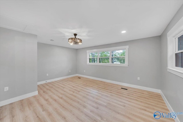 spare room featuring light wood finished floors, baseboards, visible vents, and recessed lighting